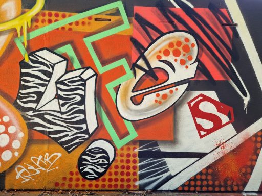 Buchstabensalat Nahaufnahme eines abstrakten Graffitis mit Zebramuster, roten Akzenten und geometrischen Formen.