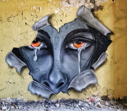 It´s okay to be not okay Ein Schwarz-Weiß-Porträt eines weinenden Gesichts, das optisch durch eine aufgerissene gelbe Wand blickt.