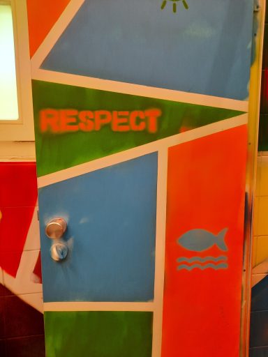 "RESPECT"-Türdesign Eine Toilettentür mit orangefarbenen und blauen Farbflächen. Darauf stehen die Worte "RESPECT" und ein kleines Fisch-Symbol ist zu sehen.